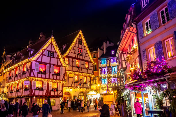 Festively illuminated houses during the Christmas market in Colmar Houses festively decorated with fairy lights at the Christmas market in Colmar, France. colmar stock pictures, royalty-free photos & images