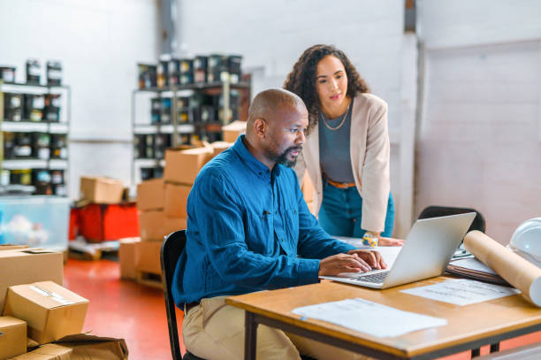 Logistics, ecommerce and business people working on laptop delivery, shipping or online shopping orders. Cargo, supply chain and checklist with employees in storage, package factory warehouse stock photo