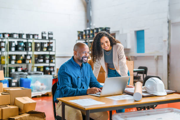 Warehouse managers, laptop logistics and shipping worker in wholesale factory, distribution technology and industry. Black people planning online stock, courier package and export delivery production stock photo