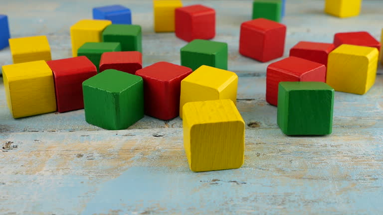 Falling baby toy blocks on an old wooden vintage board. Slow motion.