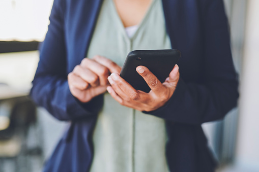Corporate, hands and phone of a business employee using app, chatting or texting over blurred background. Marketing hand of a worker testing UX or UI on mobile smartphone for communication at work