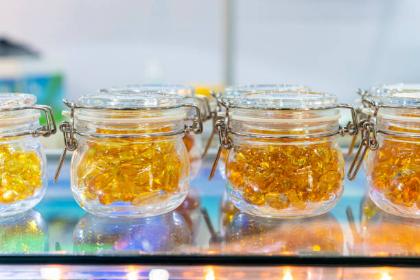 Many cod liver oil soft capsule or other look like in clear glass jar on the shelf stock photo