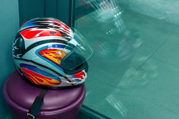 a colourful motorcyclist helemet abandoned on bench, indoor closeup