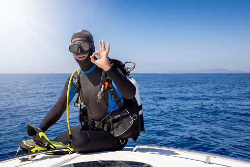 Dive master training a couple for first dive in a tropical turquoise island beach. Travel, relaxing and leisure related themes for vacations in the Caribbean. Image taken at Los Roques, Venezuela. Los Roques is an archipelago or group of small islands located at 80 miles north of the Venezuelan coastline and a very popular destination for leisure, diving, kite surfing and all king of water activities. Los Roques and the beauty of the turquoise coastal beaches of Venezuela are almost indistinguishable from those of the Bahamas, French Polynesia, Malau, Hawaii, Cancun, Costa Rica, Florida, Maldives, Cuba, Fiji, Bora Bora,  Puerto Rico, Honduras, or other tropical vacation travel destinations.