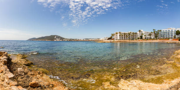 Rocky coast and clear, shallow Mediterranean sea at Santa Eulalia del Rio, Ibiza island, Balearic islands, Spain (Panorama)