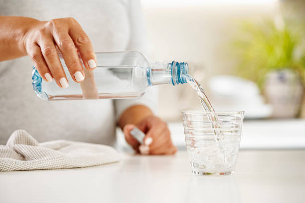 istock Pouring water from plastic bottle to a glass 1425227469