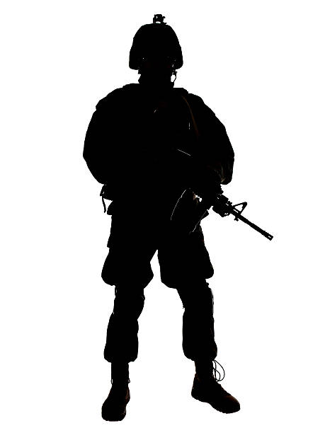 Silhouette of armed military personnel stock photo