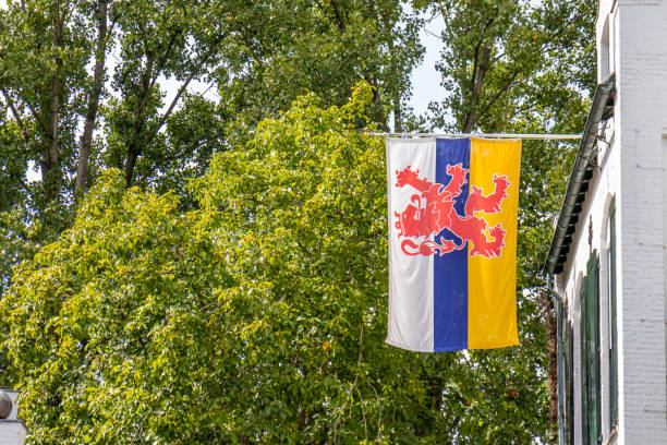 Flag of Dutch Limburg fluttering against lush green foliage stock photo