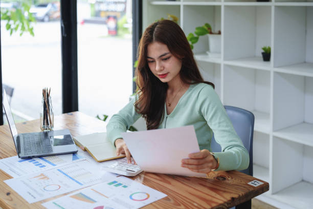istock female employee using a calculator to calculate financial documents 1425232633