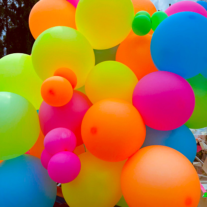 Multi-colored balls released into the blue sky.
