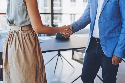 HR, recruitment and onboarding handshake at an interview or welcome meeting. Businessman and Human Resources woman shaking hands in office for we are hiring, thank you or contract B2B agreement deal