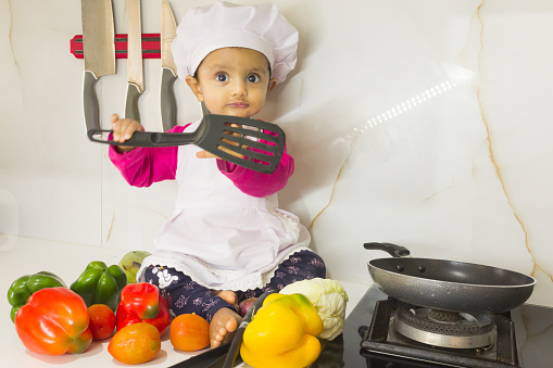 Cute Baby girls dressed as chef and making bread