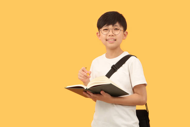 istock A student with a book is smiling happily with a bright expression. 1425240527