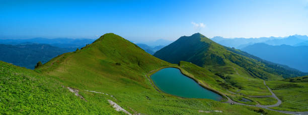 Panoramic view of Kanzelwand / Fellhorn in Kleinwalsertal in Austria, overlooking mountain lake and mountains with lush green meadow and blue sky - mountains landscape background banner panorama Panoramic view of Kanzelwand / Fellhorn in Kleinwalsertal in Austria, overlooking mountain lake and mountains with lush green meadow and blue sky - mountains landscape background banner panorama kleinwalsertal stock pictures, royalty-free photos & images