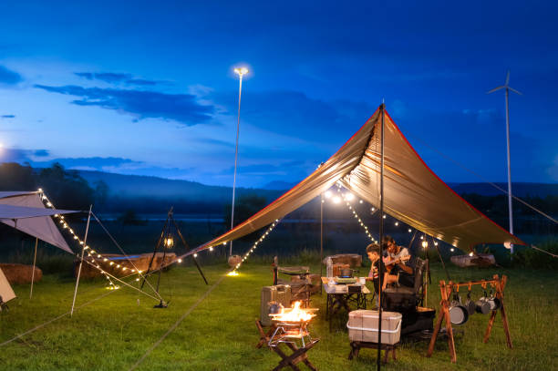 istock Night camping atmosphere. It is a low-light night shot with noise and grain. Long exposure photography causes moving parts to blur. There will be sharpness only at the selected focus point. 1425242854