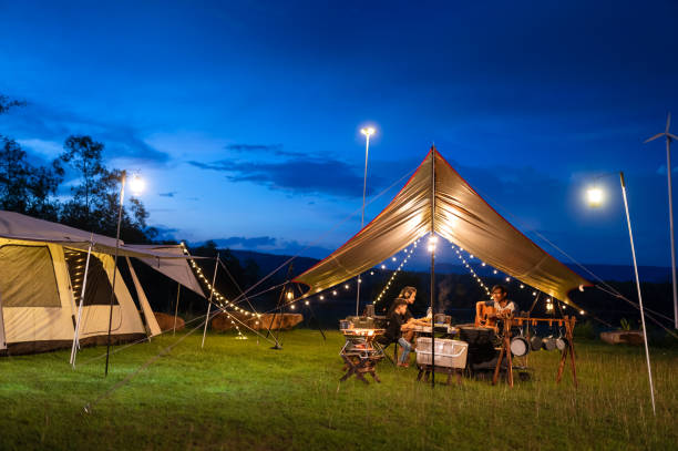 istock Night camping atmosphere. It is a low-light night shot with noise and grain. Long exposure photography causes moving parts to blur. There will be sharpness only at the selected focus point. 1425242856