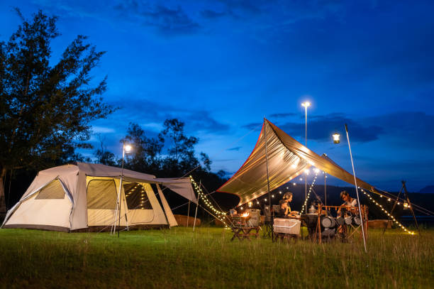 istock Night camping atmosphere. It is a low-light night shot with noise and grain. Long exposure photography causes moving parts to blur. There will be sharpness only at the selected focus point. 1425242871
