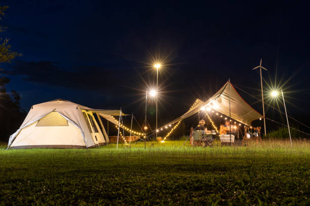 istock Night camping atmosphere. It is a low-light night shot with noise and grain. Long exposure photography causes moving parts to blur. There will be sharpness only at the selected focus point. 1425242872