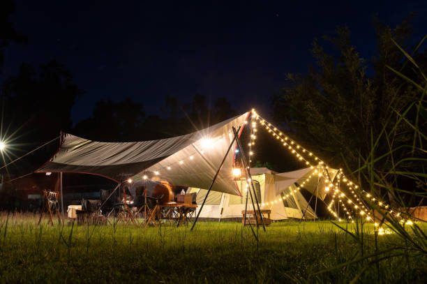 istock Night camping atmosphere. It is a low-light night shot with noise and grain. Long exposure photography causes moving parts to blur. There will be sharpness only at the selected focus point. 1425242874