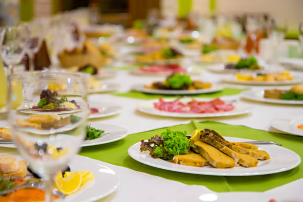 Sparkling glassware stands on long table prepared for wedding dinner.