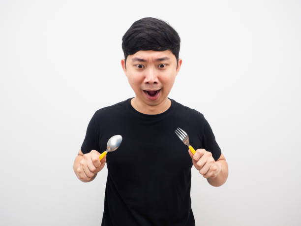 istock Man holding spoon feeling hungry and looking at food 1425248568