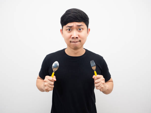 istock Asian man holding spoon feeling very hungry 1425248577
