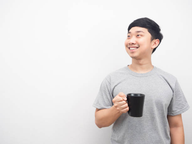 istock Man holding coffee cup smiling and looking at copy space 1425248875