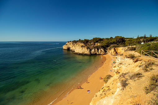 Beach with crystal blue waters in the village of Armação de Perâ, Algarve, Portugal