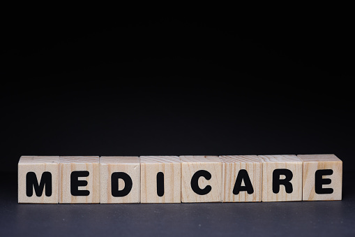 Medicare sign with wooden cubes on black background