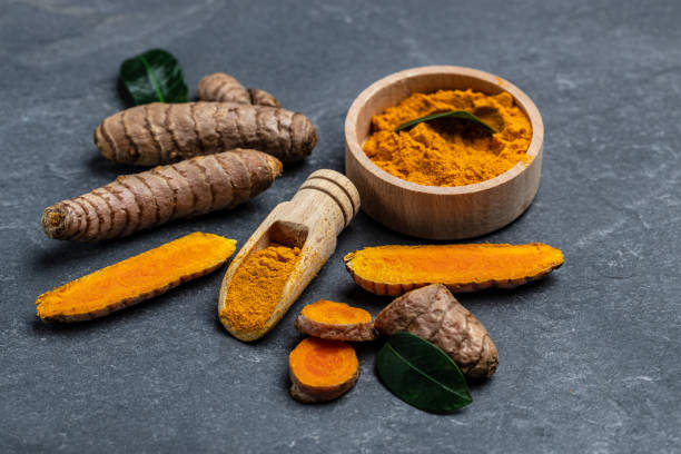 istock Turmeric powder and turmeric root on concrete background. Spice, natural coloring, alternative medicine. top view 1425250657