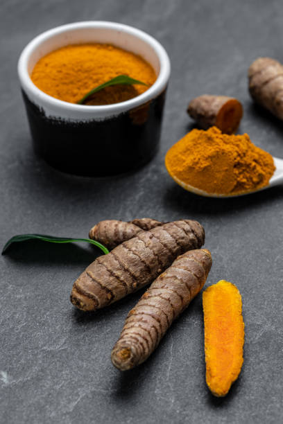 istock curcuma or curcumin root. Turmeric powder and fresh turmeric. on concrete background. Spice, natural coloring, alternative medicine. vertical image. top view 1425250660