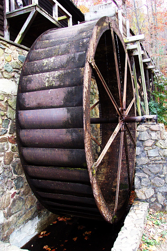 This waterwheel powered Thomas Jefferson's plantation at Monticello Vag.  It's of the more efficient overshot type, wherein the head race, or flume carries water to the top of the wheel which catches the water in its paddles, and the force of the water momentum plus its weight turns the wheel and its axle.