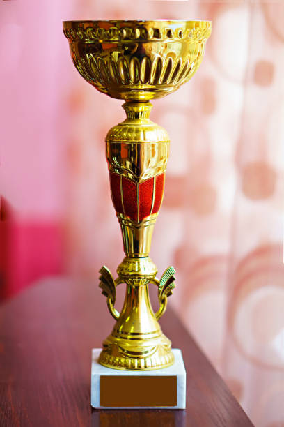 istock Gold Cup on wooden table 1425254370