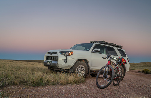 Fort Collins, CO, USA - September 18, 2022: Toyota 4Runner SUV and Checkpoint SL6 gravel bike by Trek at a trailhead in Soapstone Prairie Natural Area in Colorado foothills.