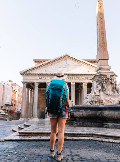istock Young girl walks exploring the city with her backpack on a sunny day, digital nomad, vertical shot 1425267445