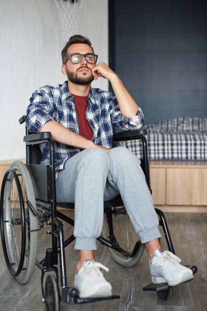 Man sitting in wheelchair at home stock photo