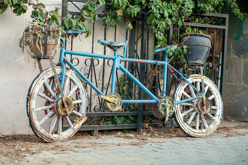 View of a tandem bike with a flower pot on, decorating the street.