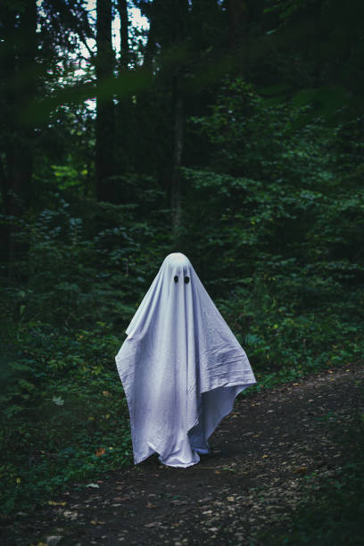 istock A child in a white sheet pretends to be a ghost on Halloween 1425274886