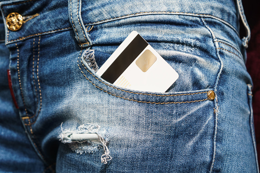 Closeup of credit card in jeans trousers pocket.