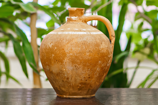 Old vintage antique earthenware jug on the table. Vintage style. Vessel for water , made for Scythian.