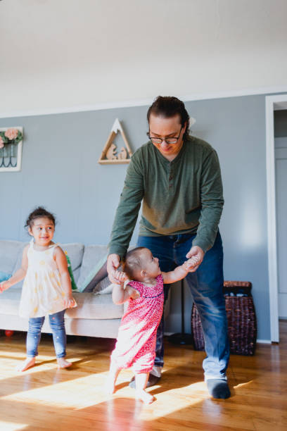 istock Father and Daughters Happily Playing Together At Home 1425279107