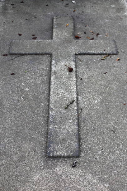 istock Cross in a tombstone 1425280446