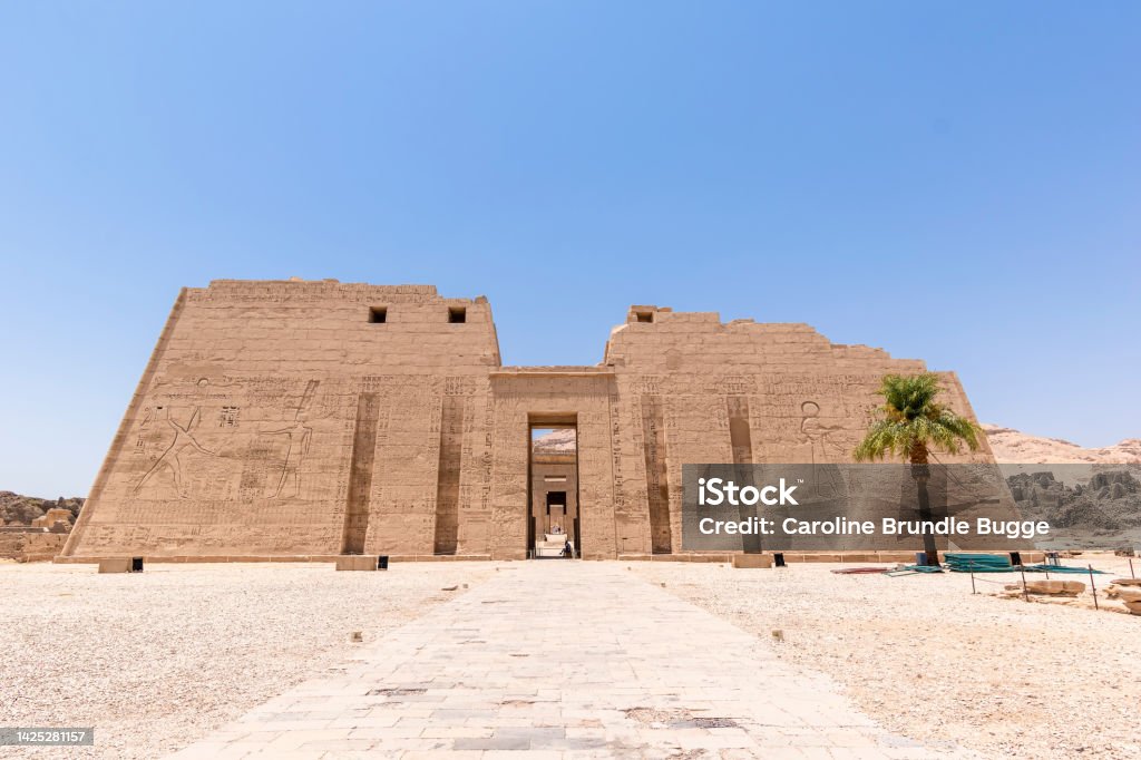 The Temple of Ramesses III, Luxor, Egypt The Temple of Ramesses III, Luxor, Egypt - July 26, 2022:  The Temple of Ramesses III at Medinet Habu was an important New Kingdom period temple structure in the West Bank of Luxor in Egypt. Aside from its size and architectural and artistic importance, the mortuary temple is probably best known as the source of inscribed reliefs depicting the advent and defeat of the Sea Peoples during the reign of Ramesses III. Medinet Habu Stock Photo