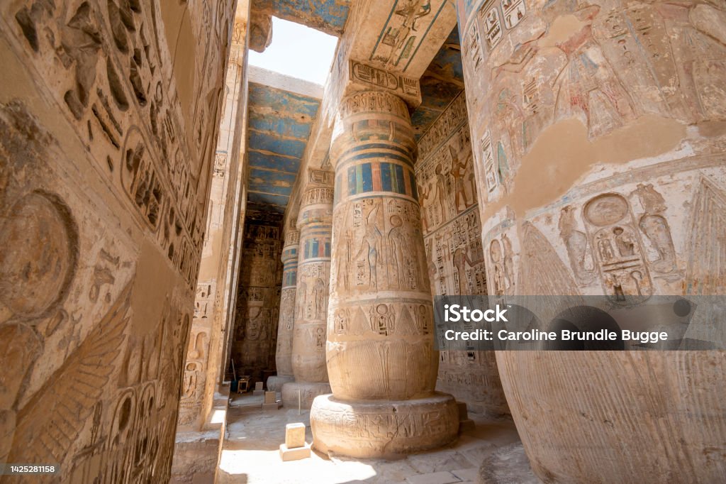 The Temple of Ramesses III, Luxor, Egypt The Temple of Ramesses III, Luxor, Egypt - July 26, 2022:  The Temple of Ramesses III at Medinet Habu was an important New Kingdom period temple structure in the West Bank of Luxor in Egypt. Aside from its size and architectural and artistic importance, the mortuary temple is probably best known as the source of inscribed reliefs depicting the advent and defeat of the Sea Peoples during the reign of Ramesses III. Hieroglyphics Stock Photo