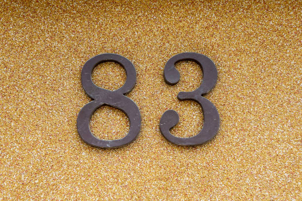 house number eighty-three on the beige wall 83