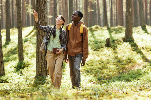 istock Multiethnic couple walking in the forest 1425281678