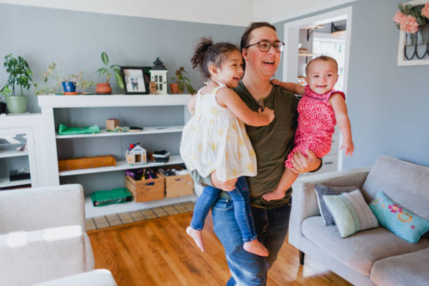 istock Father and Daughters Happily Playing Together At Home 1425282873