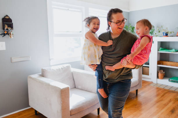 istock Father and Daughters Happily Playing Together At Home 1425282879