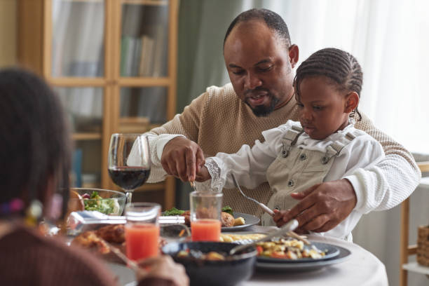 istock Father helping his child to eat meal 1425283738