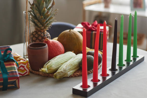 Seven candles with fruits for Kwanzaa holiday Close-up of seven candles with exotic fruits on table preparing for Kwanzaa holiday angolan kwanza photos stock pictures, royalty-free photos & images